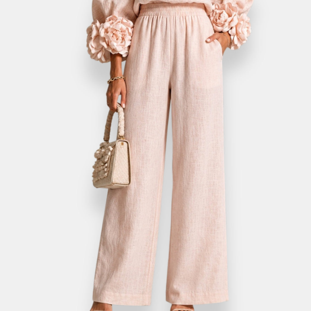 Rear view of sophisticated black wide-leg trousers, highlighting the elasticated waistband and smooth silhouette.