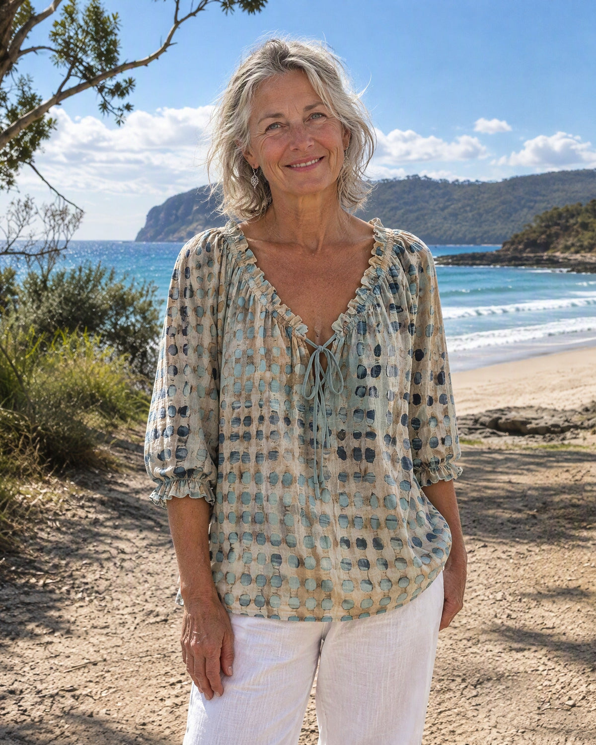Front view of the Xylia blouse in teal, showcasing its relaxed fit and ruffled tie-neck design.