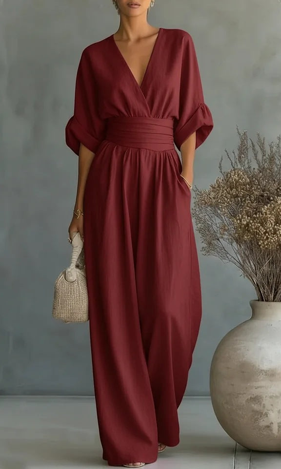 A burgundy jumpsuit worn by a seated model, highlighting the relaxed fit and all-day comfort.