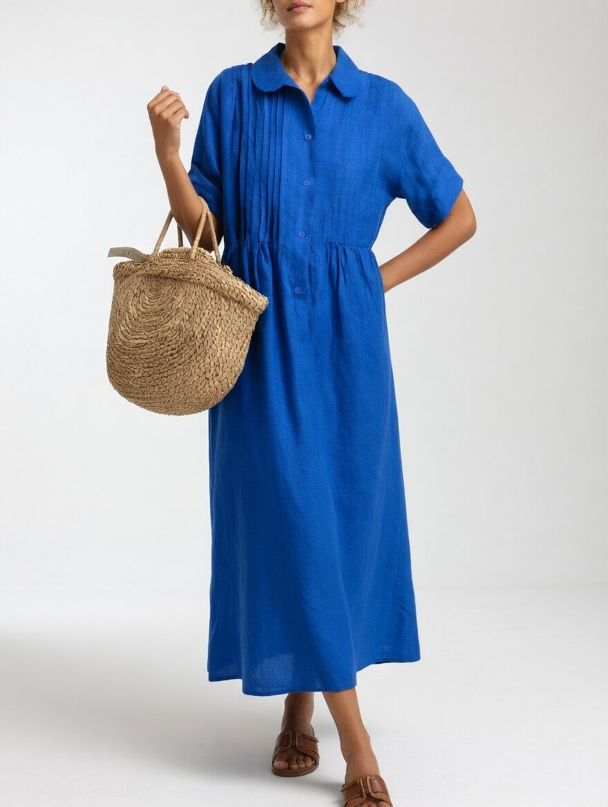 Close-up detail of the shirt collar and front button placket on a black relaxed cotton dress.