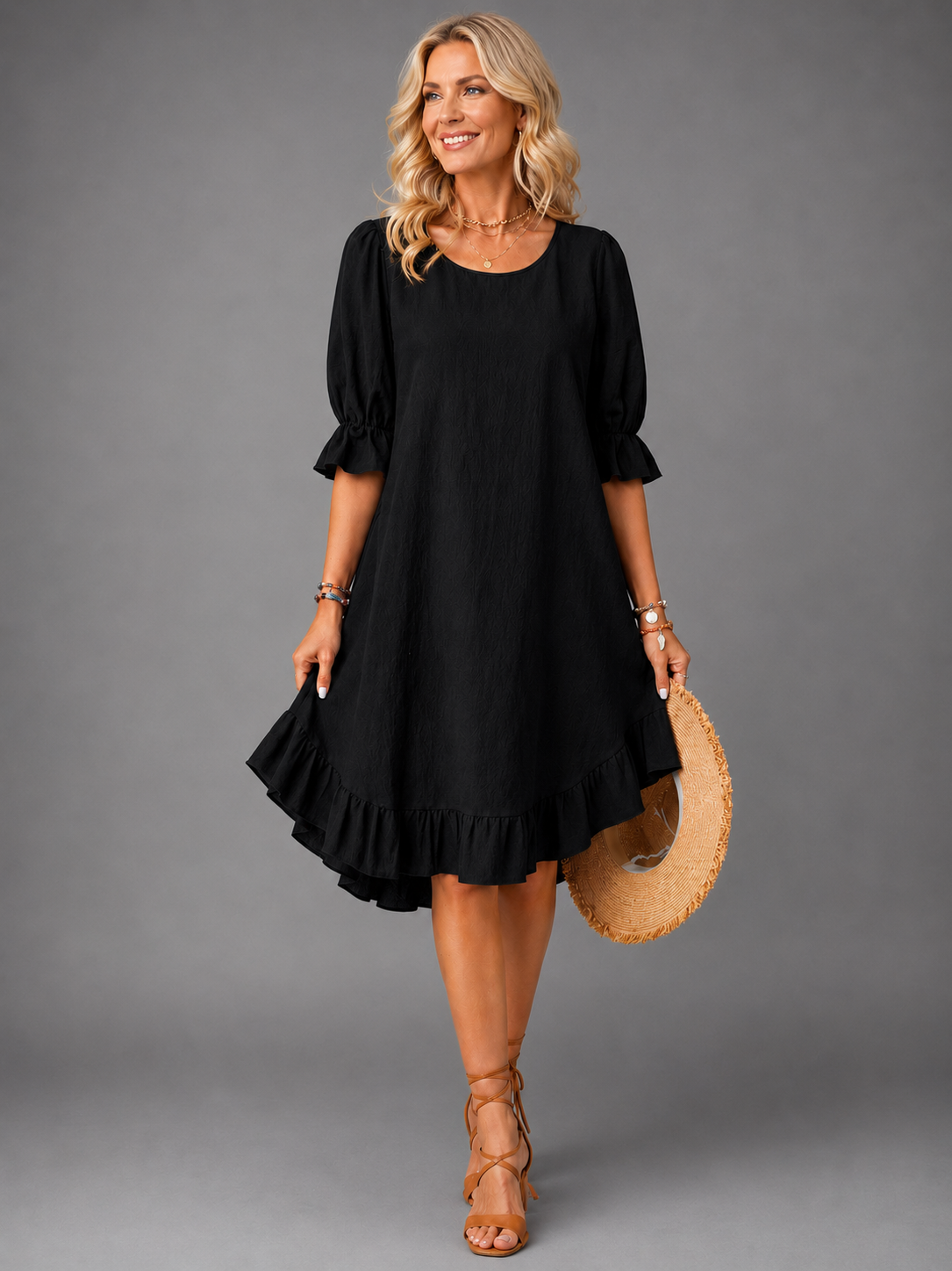 Close-up detail of the ruffle hem on a black Zenia dress, showing the feminine design.
