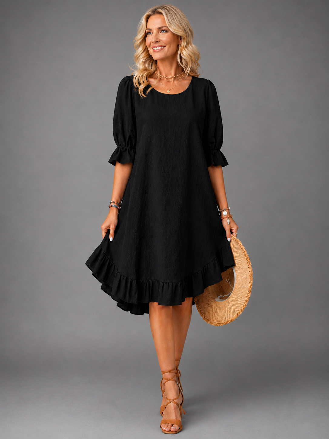 Close-up detail of the ruffle hem on a black Zenia dress, showing the feminine design.