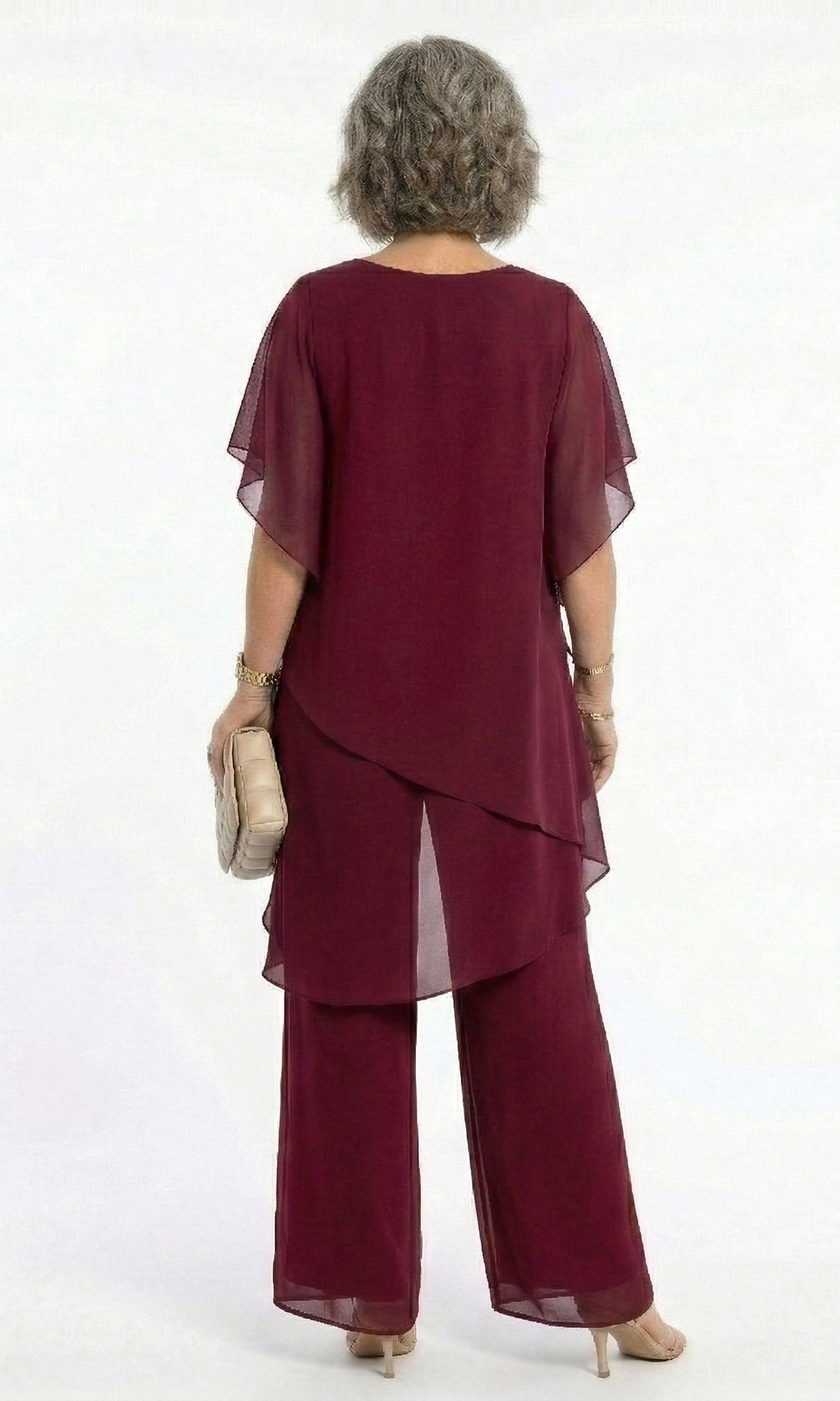 Back view of the blush pink tiered blouse, revealing its gentle lines and sophisticated, modest coverage.