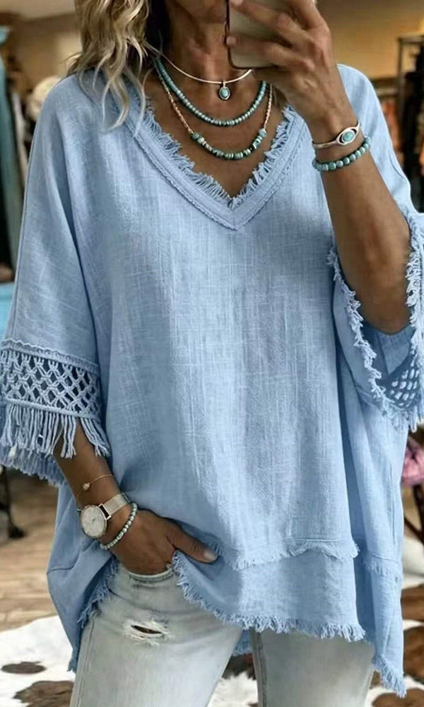 Close-up detail of the crochet-inspired trim on the sleeve of the blue bohemian blouse.
