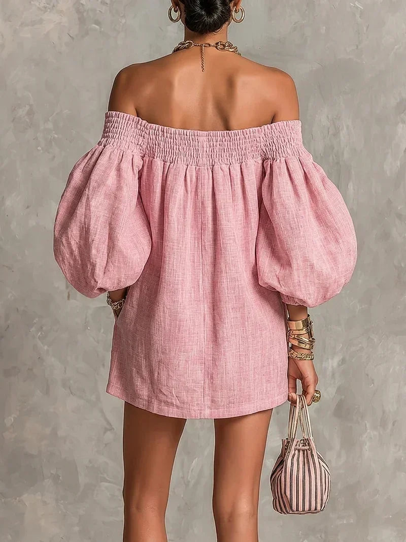 Close-up of the shirred neckline and light linen-effect fabric on the pink off-shoulder mini dress.
