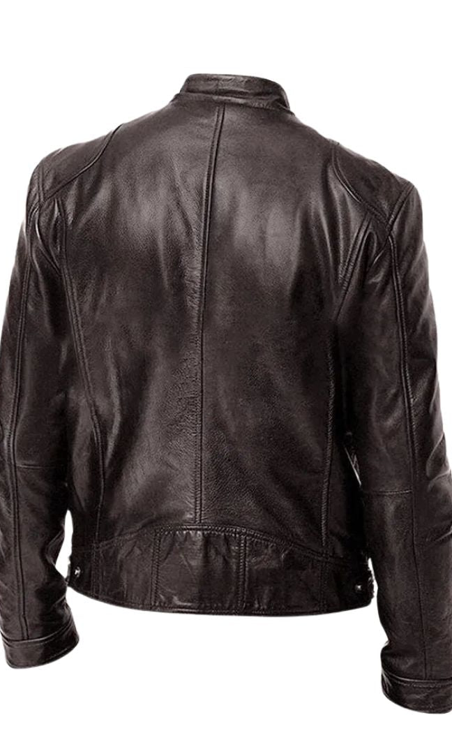 A grey Alden men's leather jacket draped over a chair, illustrating its relaxed yet refined presence.