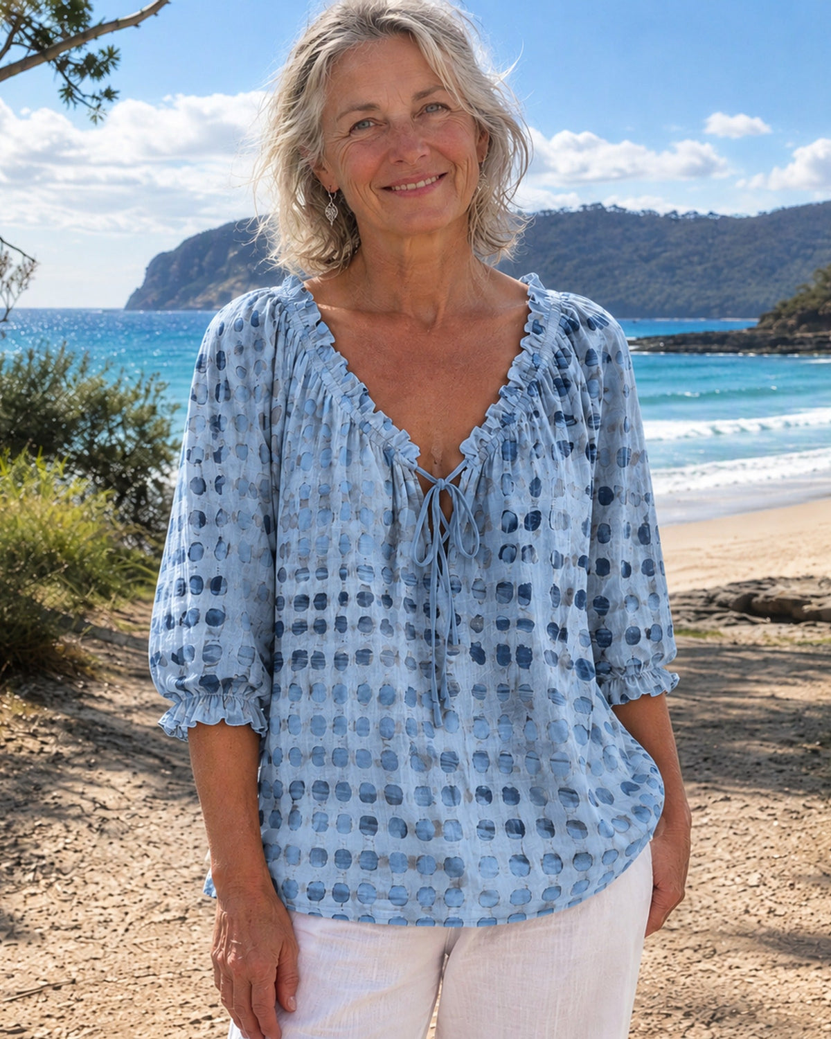 Back view of the mist blue Xylia blouse, showing the soft drape of the linen-look polyester fabric.