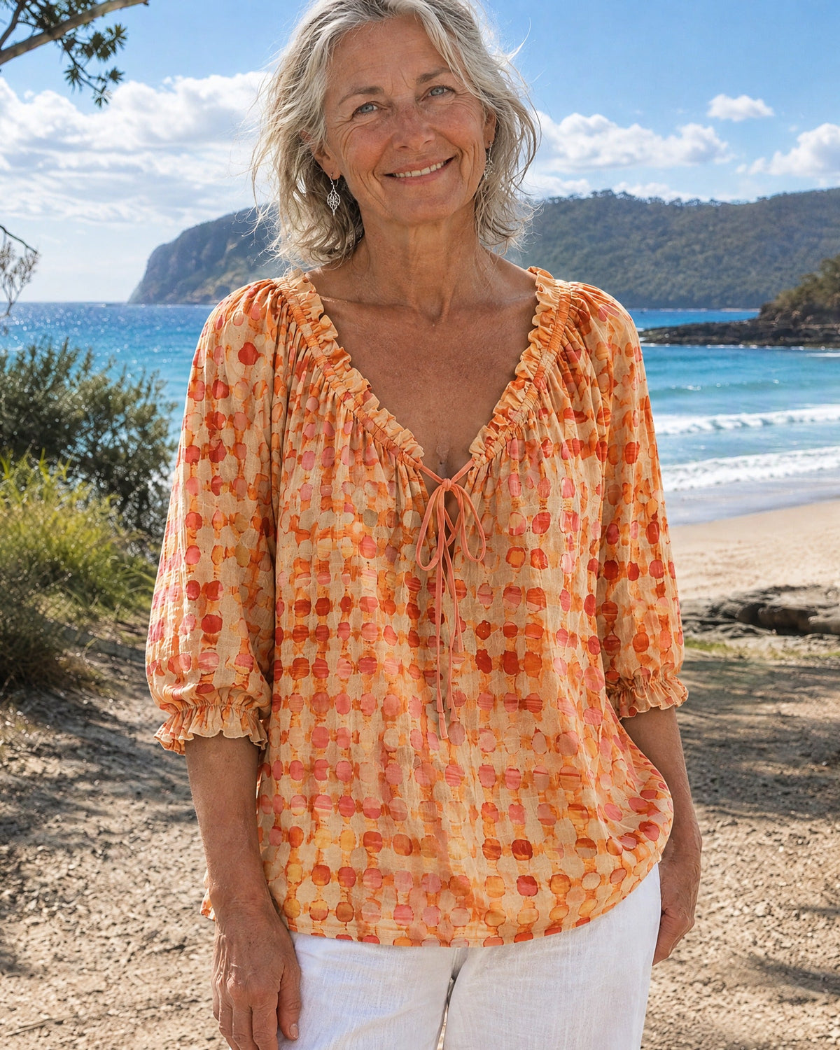 Orange Xylia blouse on a hanger, displaying the overall shape and texture of this stylish garment.