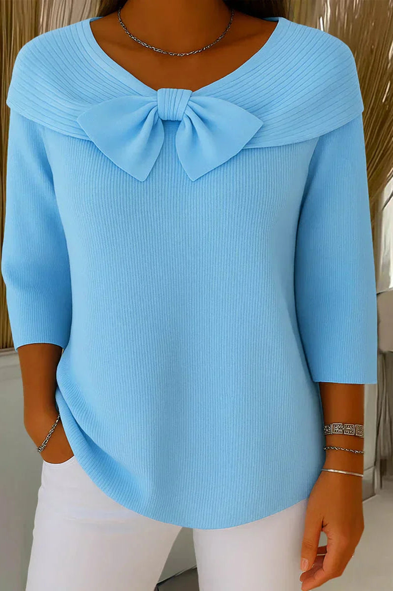 Front view of a woman wearing the blue elegant knitted top with a delicate bow, showcasing its flattering silhouette.