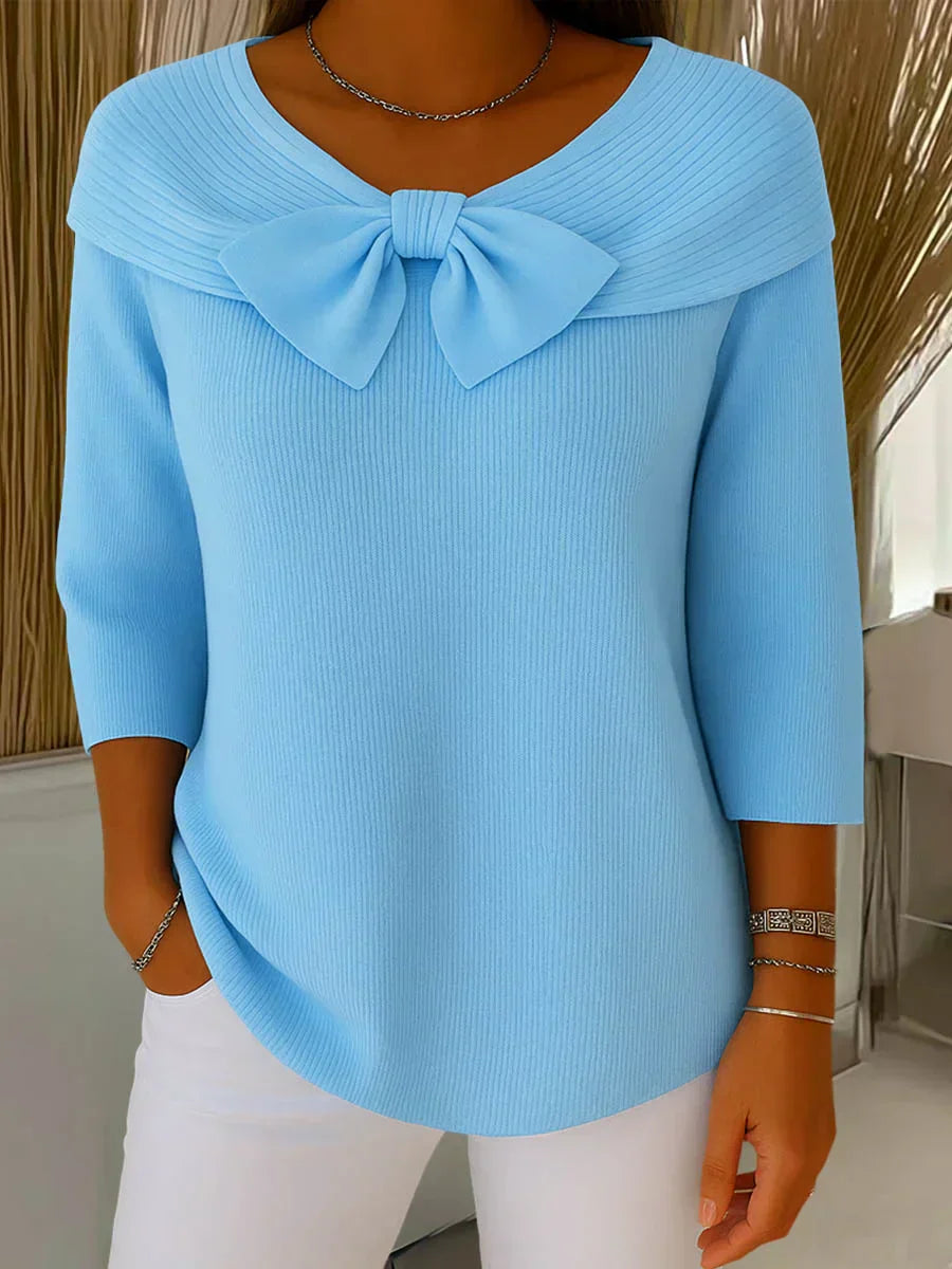 Front view of a woman wearing the blue elegant knitted top with a delicate bow, showcasing its flattering silhouette.