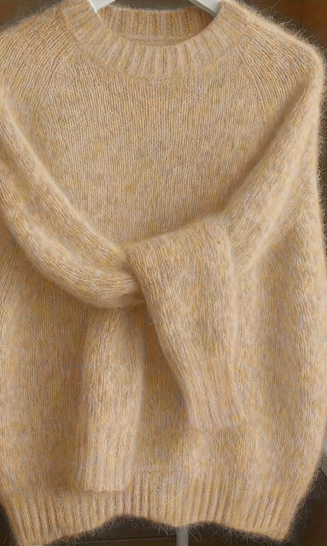 Front view of a woman wearing the apricot Elara cashmere-blend sweater, showcasing its relaxed fit and soft drape.