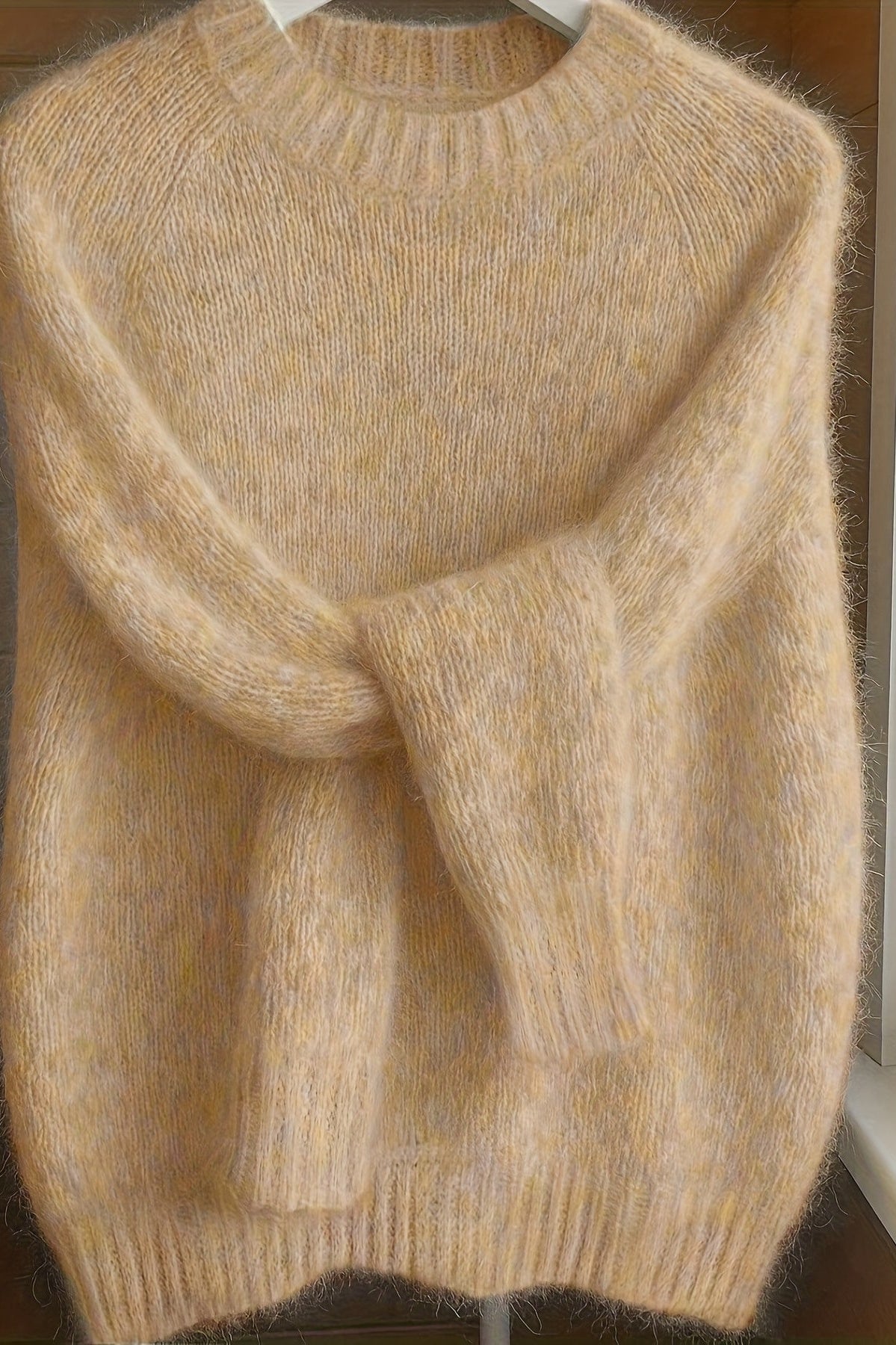 Front view of a woman wearing the apricot Elara cashmere-blend sweater, showcasing its relaxed fit and soft drape.