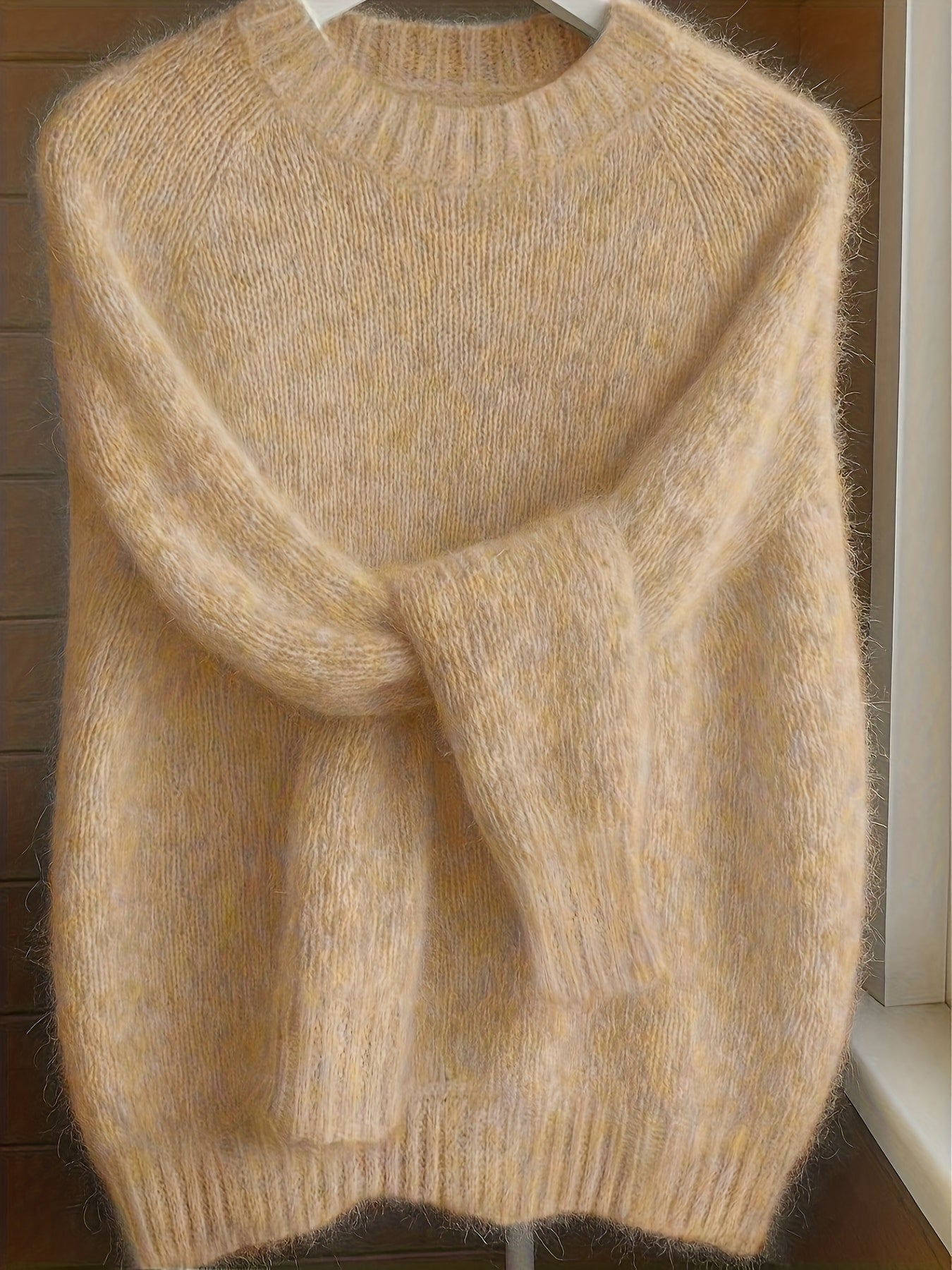 Front view of a woman wearing the apricot Elara cashmere-blend sweater, showcasing its relaxed fit and soft drape.