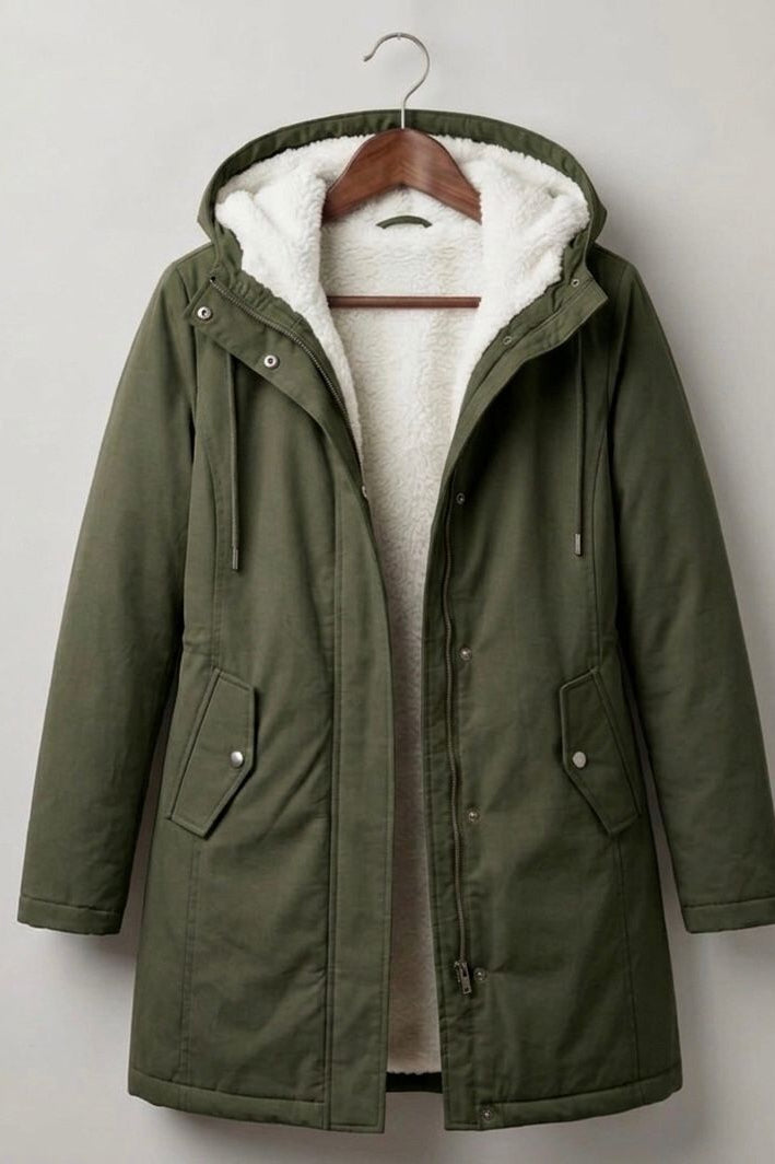 Lifestyle shot of a woman comfortably walking in the Elara parka during a brisk, rainy morning.