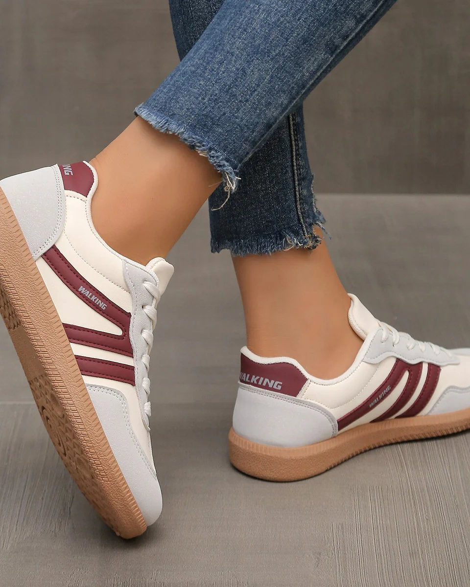 Side view of a wine red Elara orthopaedic cushioned trainer, presenting its rich color and ergonomic form.