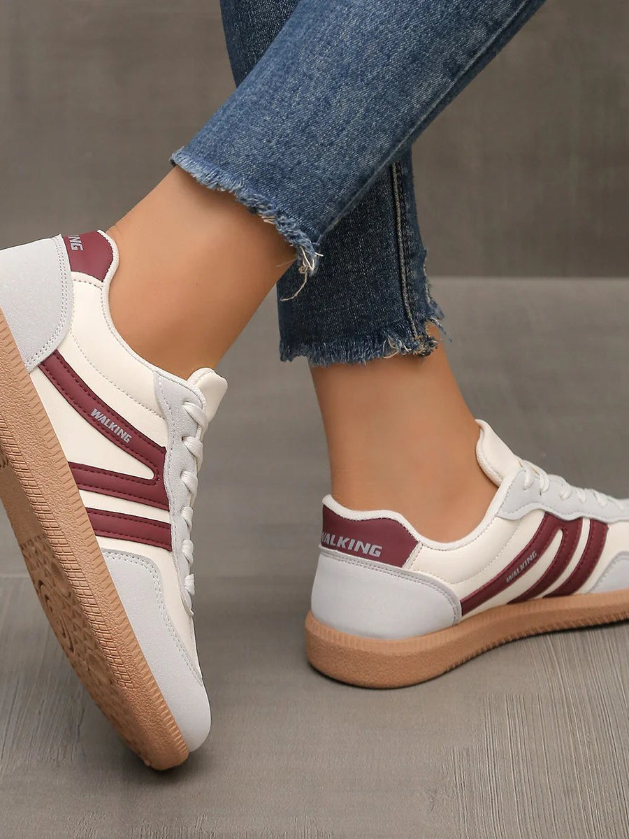 Side view of a wine red Elara orthopaedic cushioned trainer, presenting its rich color and ergonomic form.