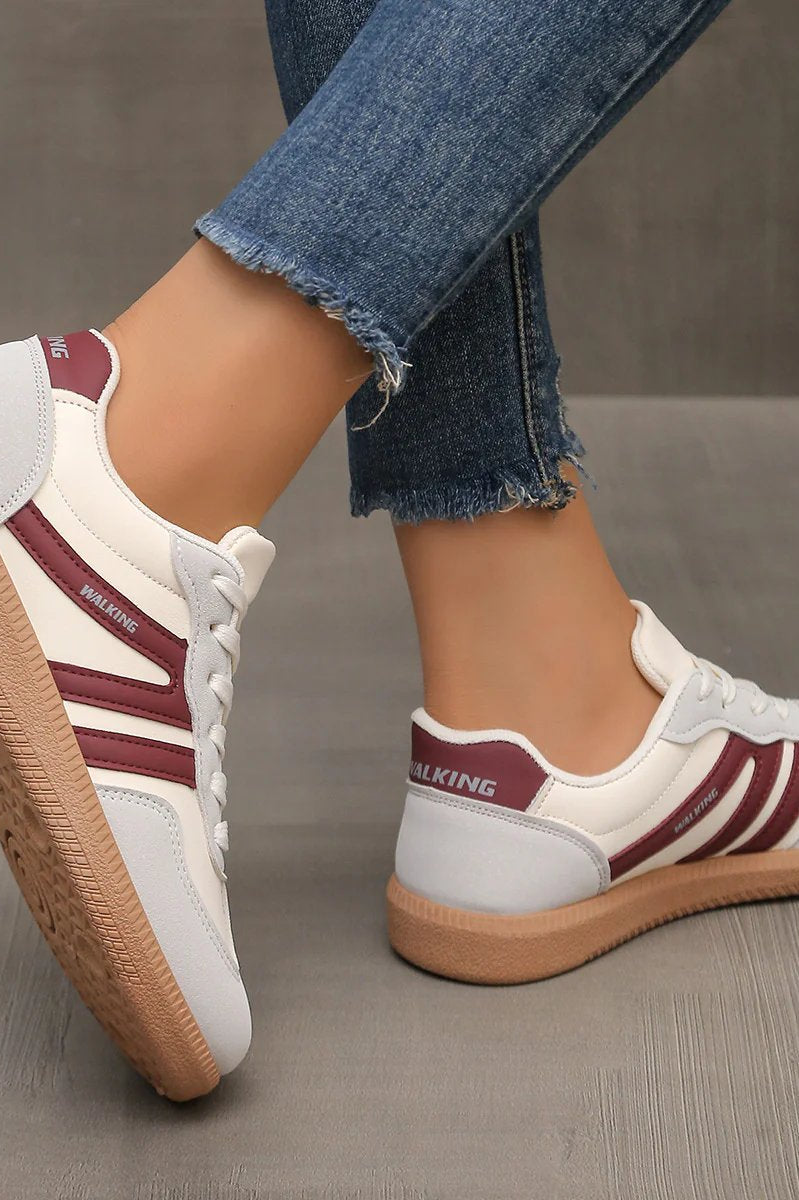 Side view of a wine red Elara orthopaedic cushioned trainer, presenting its rich color and ergonomic form.