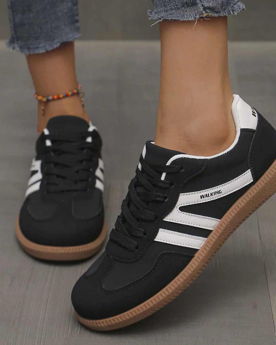 Frontal view of the off-white Elara orthopaedic cushioned trainer, highlighting the breathable mesh and lace-up detail.