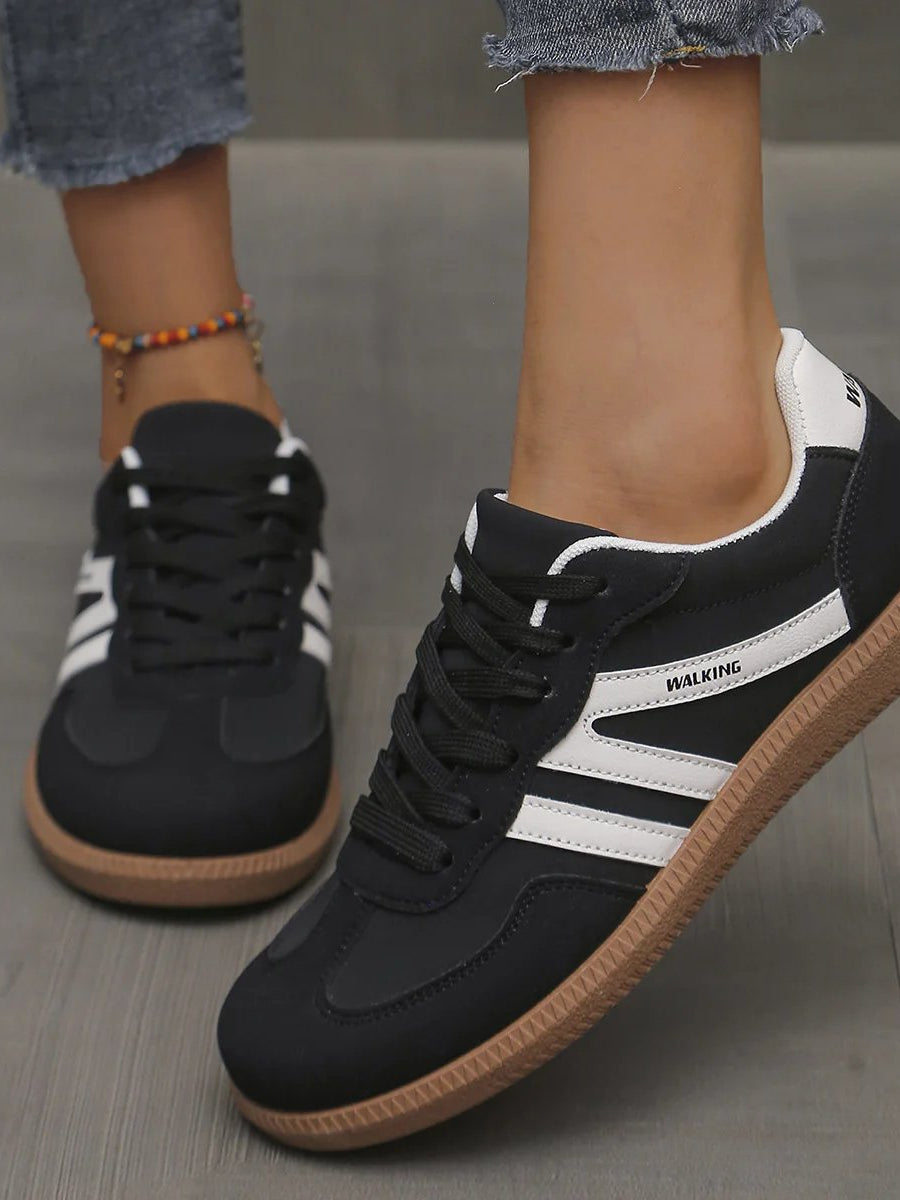 Frontal view of the off-white Elara orthopaedic cushioned trainer, highlighting the breathable mesh and lace-up detail.