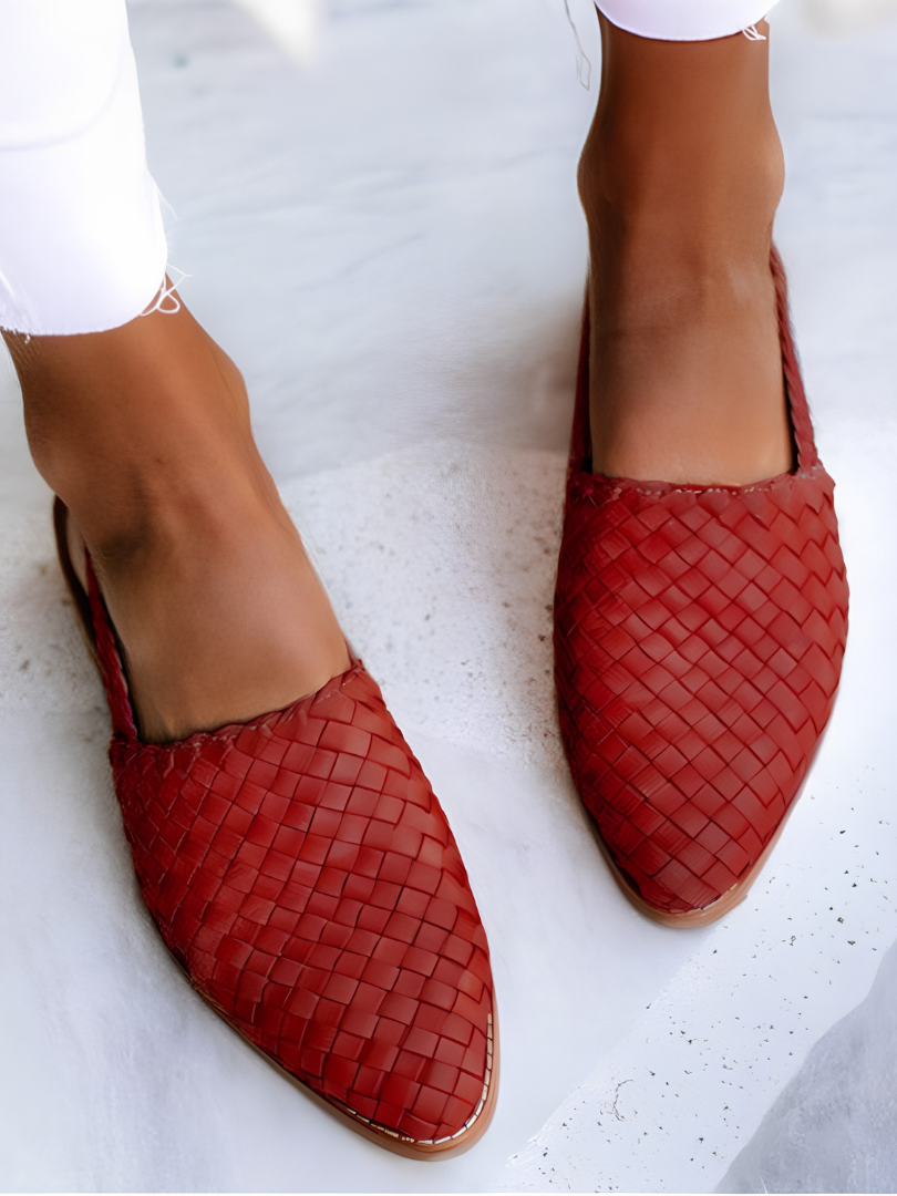 Close-up of the red handcrafted moccasins' woven pattern and stitching, emphasizing the quality of craftsmanship.