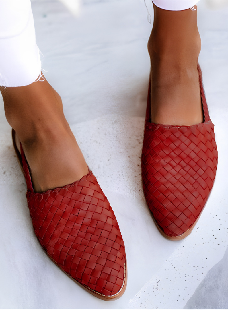 Close-up of the red handcrafted moccasins' woven pattern and stitching, emphasizing the quality of craftsmanship.