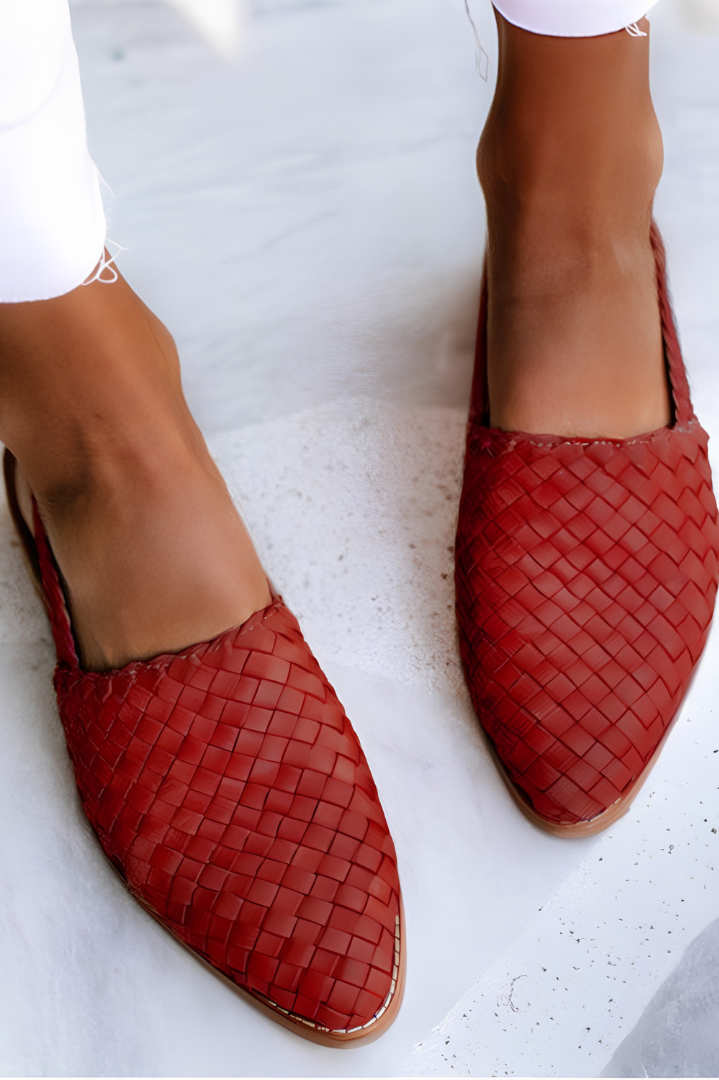 Close-up of the red handcrafted moccasins' woven pattern and stitching, emphasizing the quality of craftsmanship.