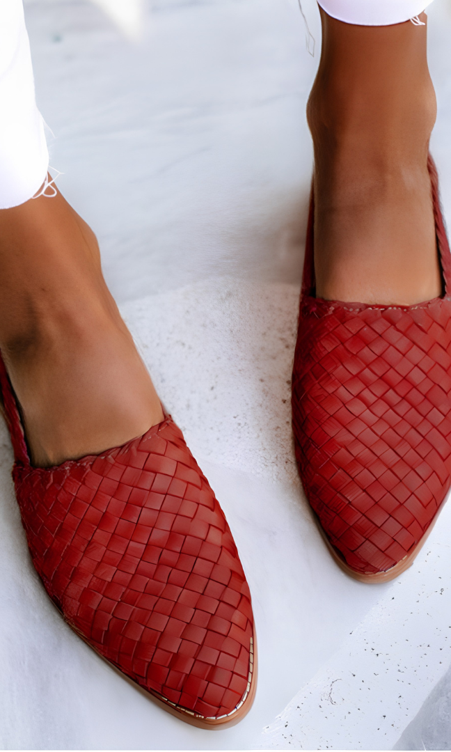 Close-up of the red handcrafted moccasins' woven pattern and stitching, emphasizing the quality of craftsmanship.