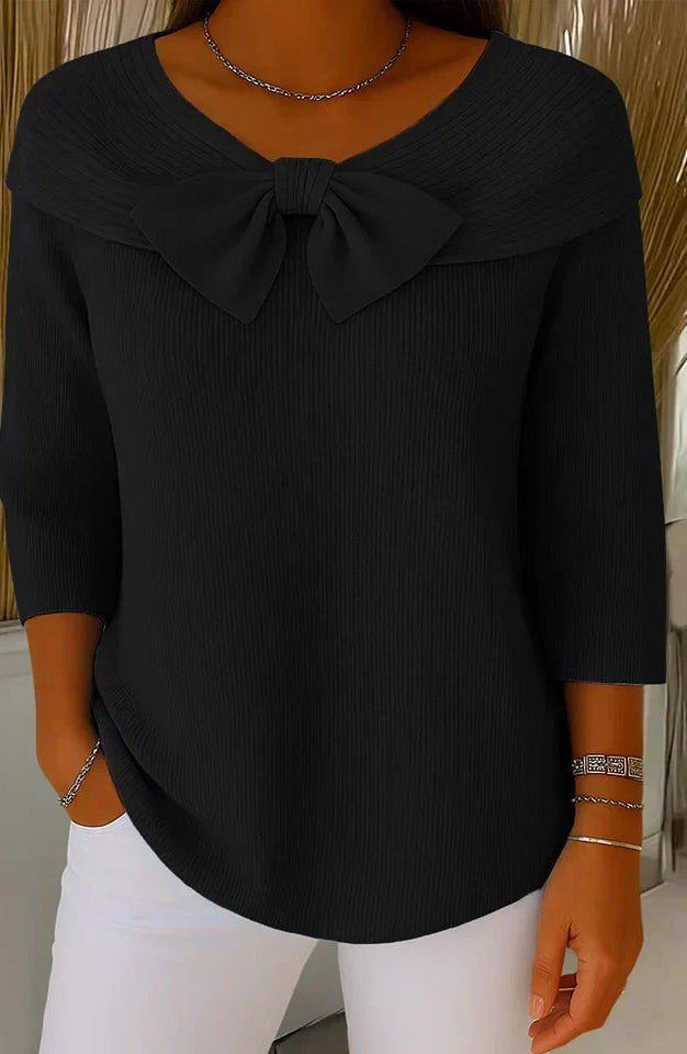 Lifestyle shot of a woman in the black elegant knitted top, paired with accessories, suitable for an evening out.