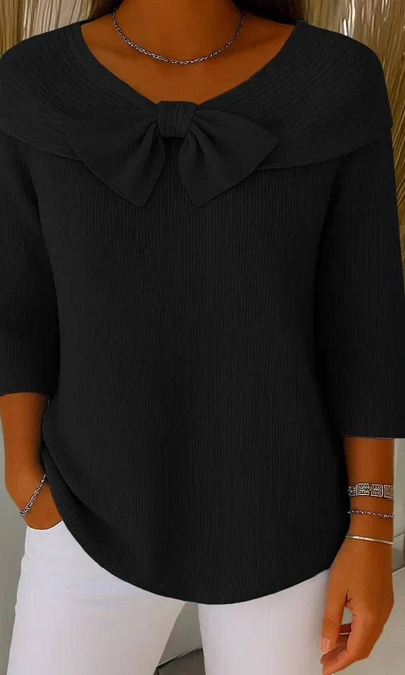 Lifestyle shot of a woman in the black elegant knitted top, paired with accessories, suitable for an evening out.
