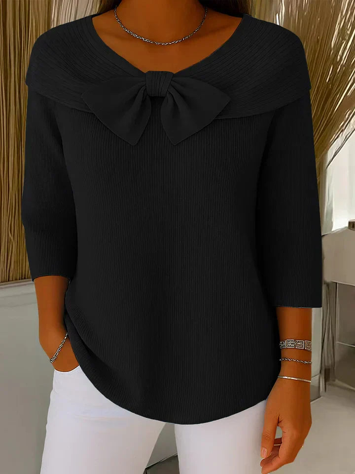 Lifestyle shot of a woman in the black elegant knitted top, paired with accessories, suitable for an evening out.