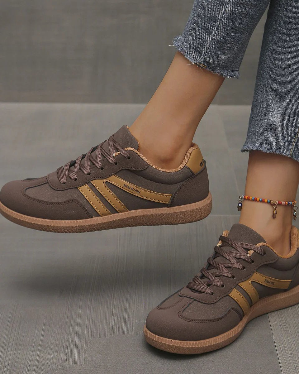 Pair of off-white Elara orthopaedic cushioned trainers displayed on a clean surface, emphasizing their modern aesthetic.