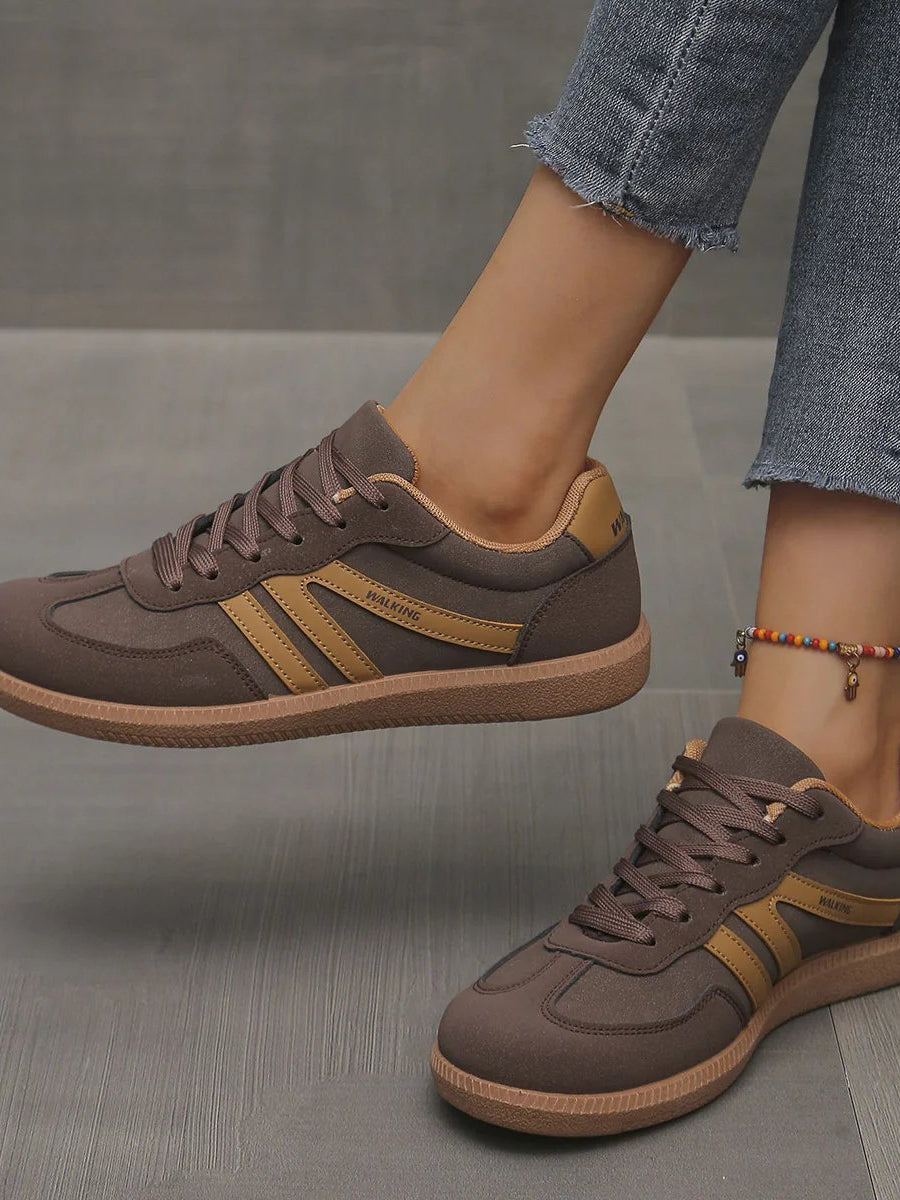 Pair of off-white Elara orthopaedic cushioned trainers displayed on a clean surface, emphasizing their modern aesthetic.