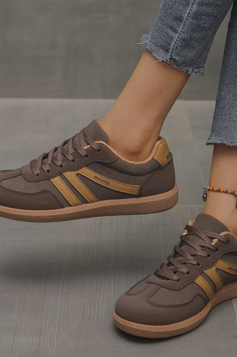 Pair of off-white Elara orthopaedic cushioned trainers displayed on a clean surface, emphasizing their modern aesthetic.