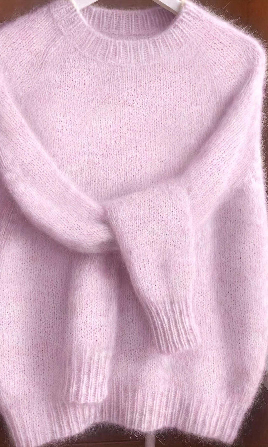 A stack of folded Elara cashmere-blend sweaters in various colors, emphasizing the quality and rich palette.