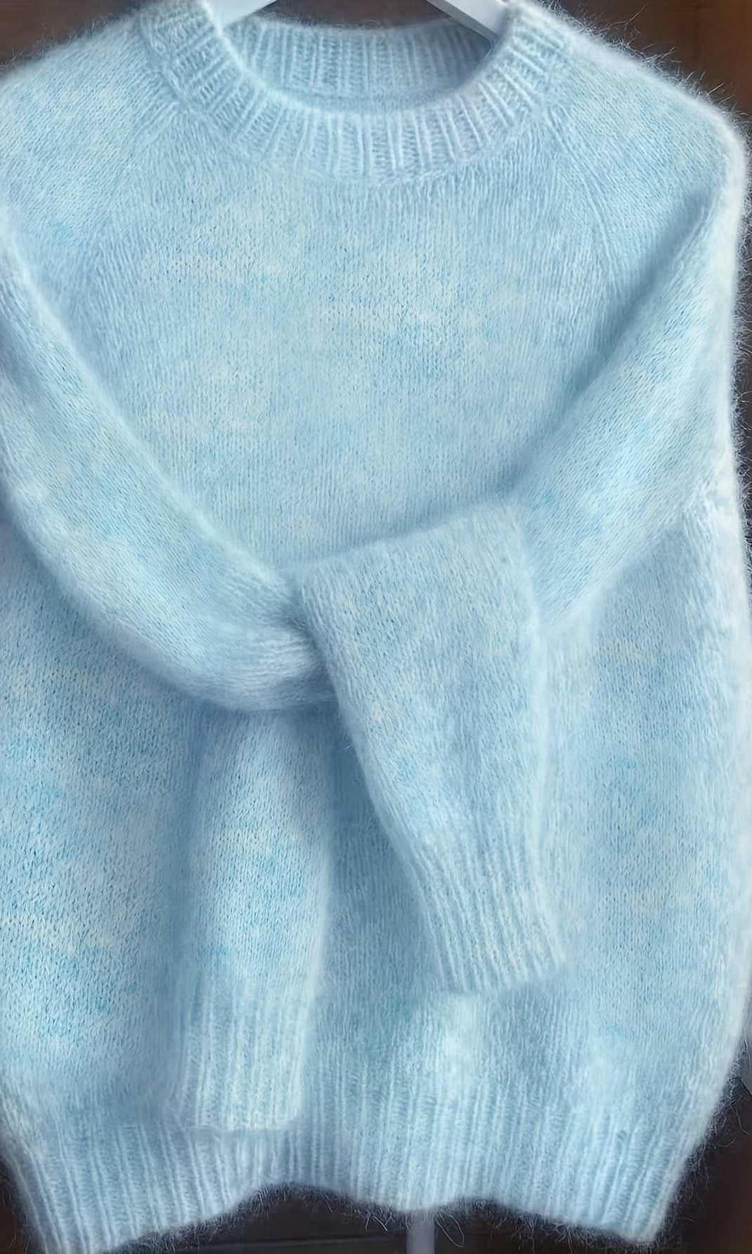 Woman casually styled in the blue Elara cashmere-blend sweater, paired with jeans for an effortless, chic look.