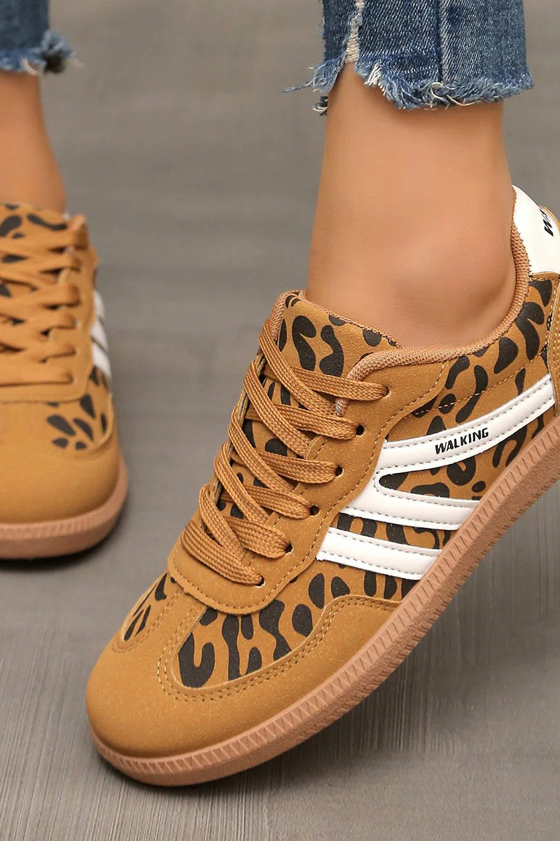 Lifestyle shot of a woman wearing off-white Elara orthopaedic cushioned trainers while walking outdoors, showing comfort in motion.