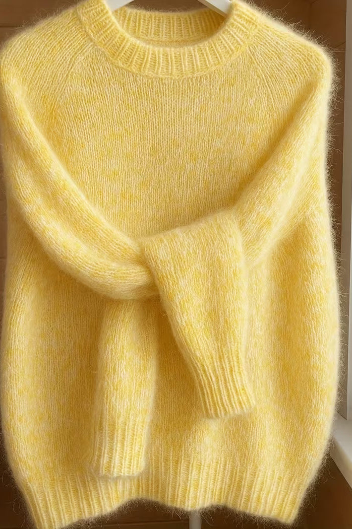 Detail shot of the crew neck and shoulder seam of the orange Elara cashmere-blend sweater, focusing on craftsmanship.