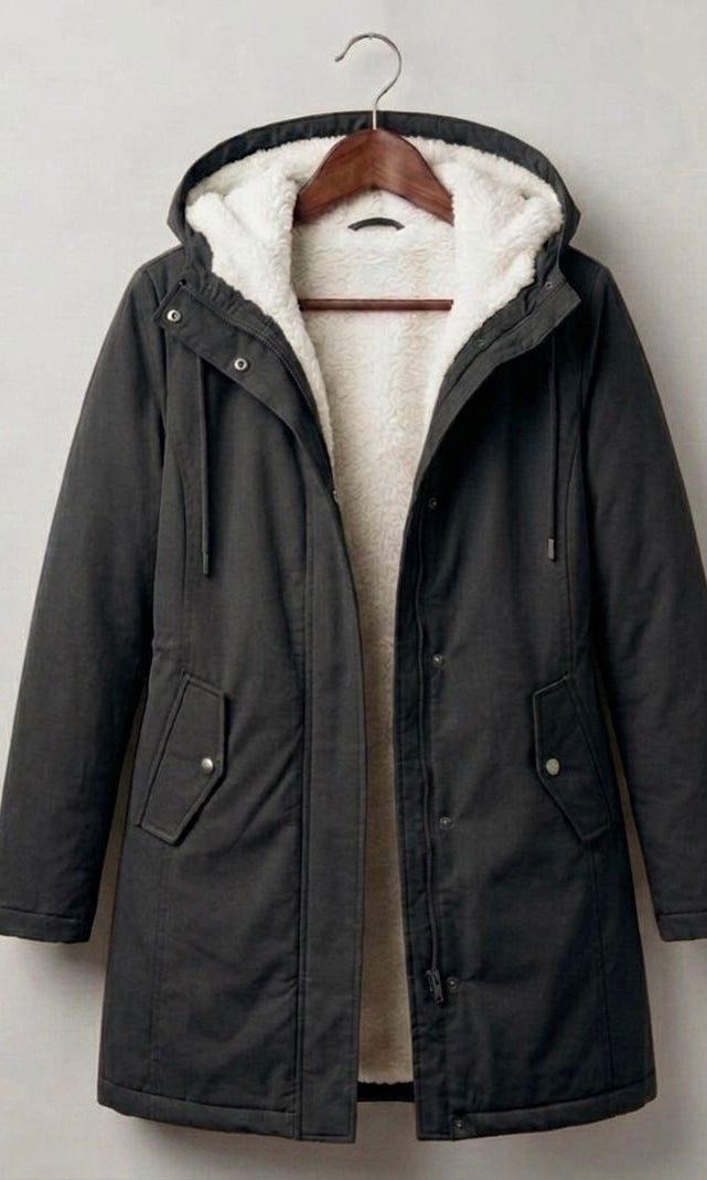 Close-up on the functional storm hood of the Elara parka, designed for comprehensive face and hair protection.