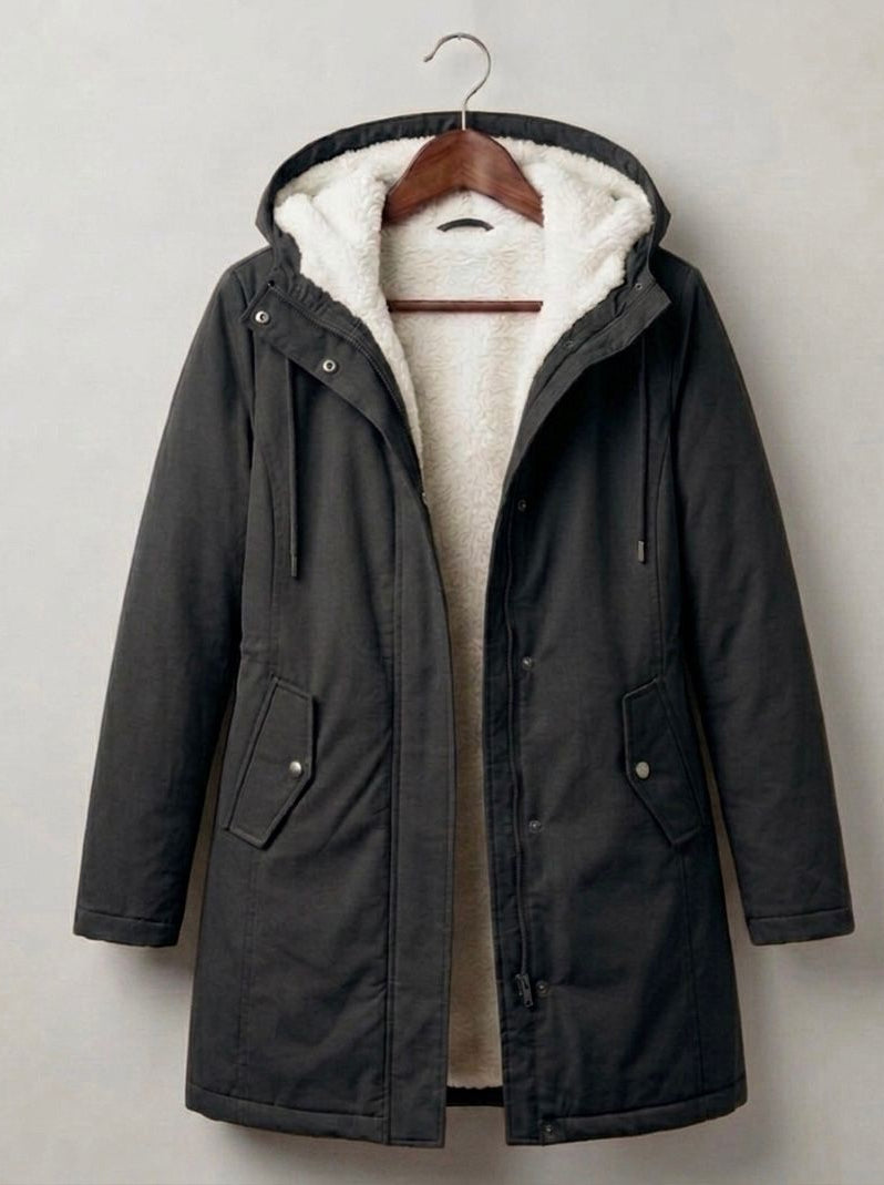 Close-up on the functional storm hood of the Elara parka, designed for comprehensive face and hair protection.