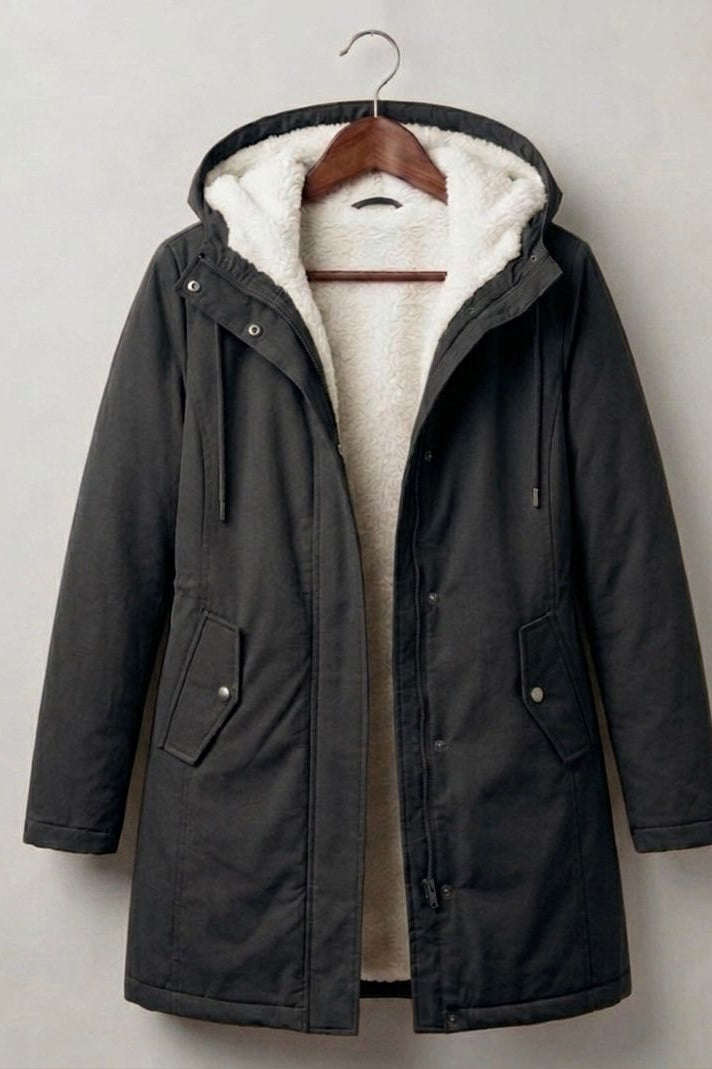 Close-up on the functional storm hood of the Elara parka, designed for comprehensive face and hair protection.