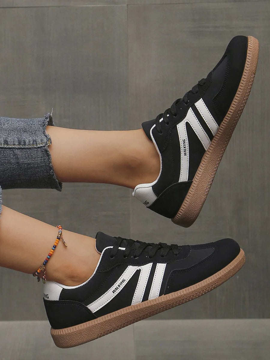 Angled shot of the black Elara orthopaedic cushioned trainer, showcasing its contrast sole and secure lacing system.