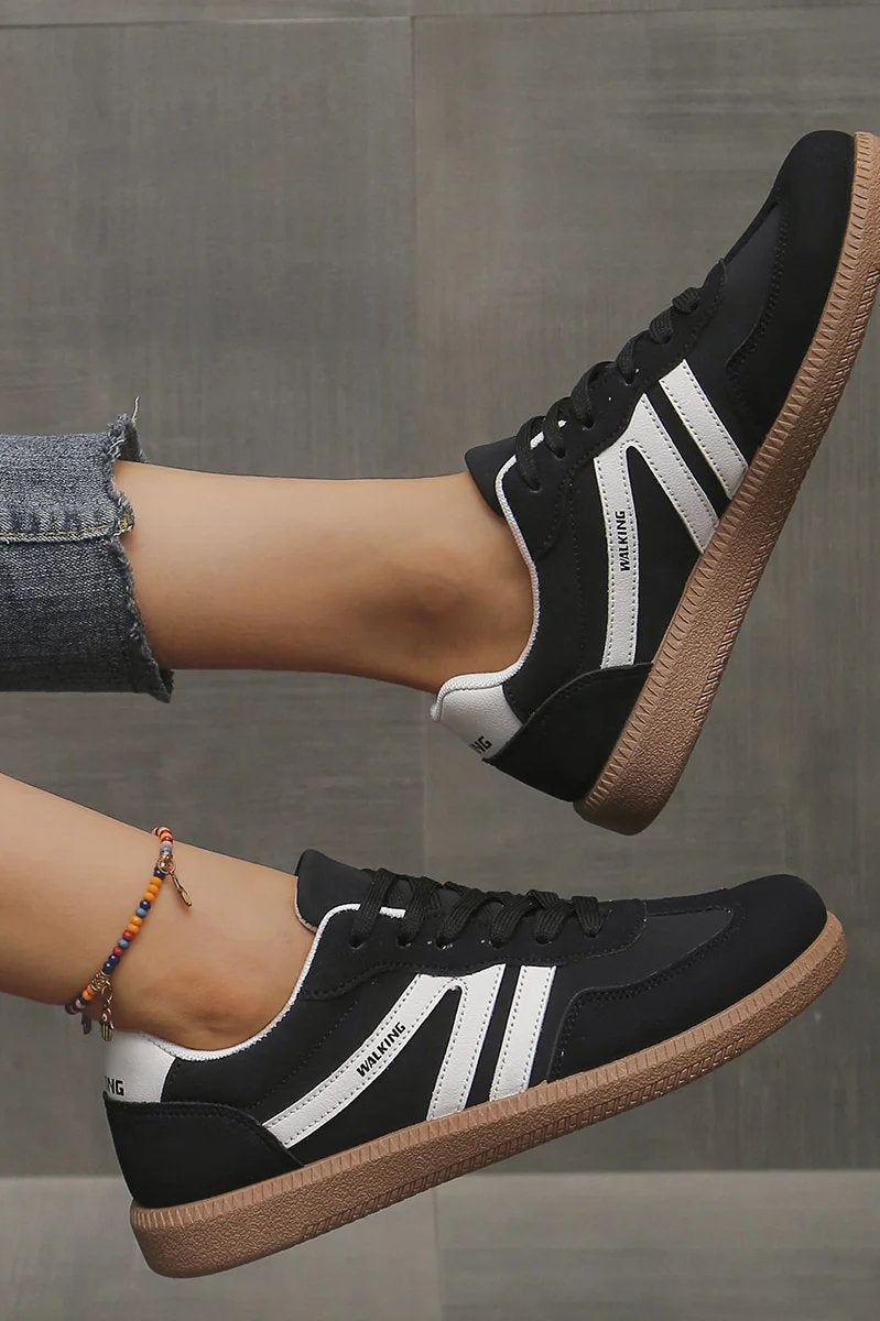 Angled shot of the black Elara orthopaedic cushioned trainer, showcasing its contrast sole and secure lacing system.