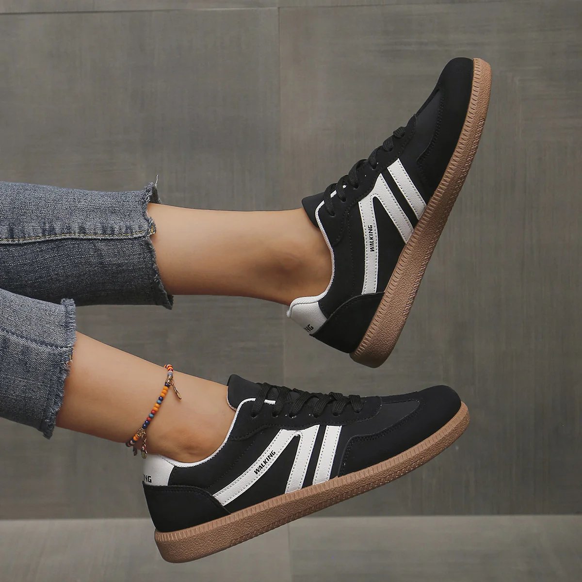 Angled shot of the black Elara orthopaedic cushioned trainer, showcasing its contrast sole and secure lacing system.