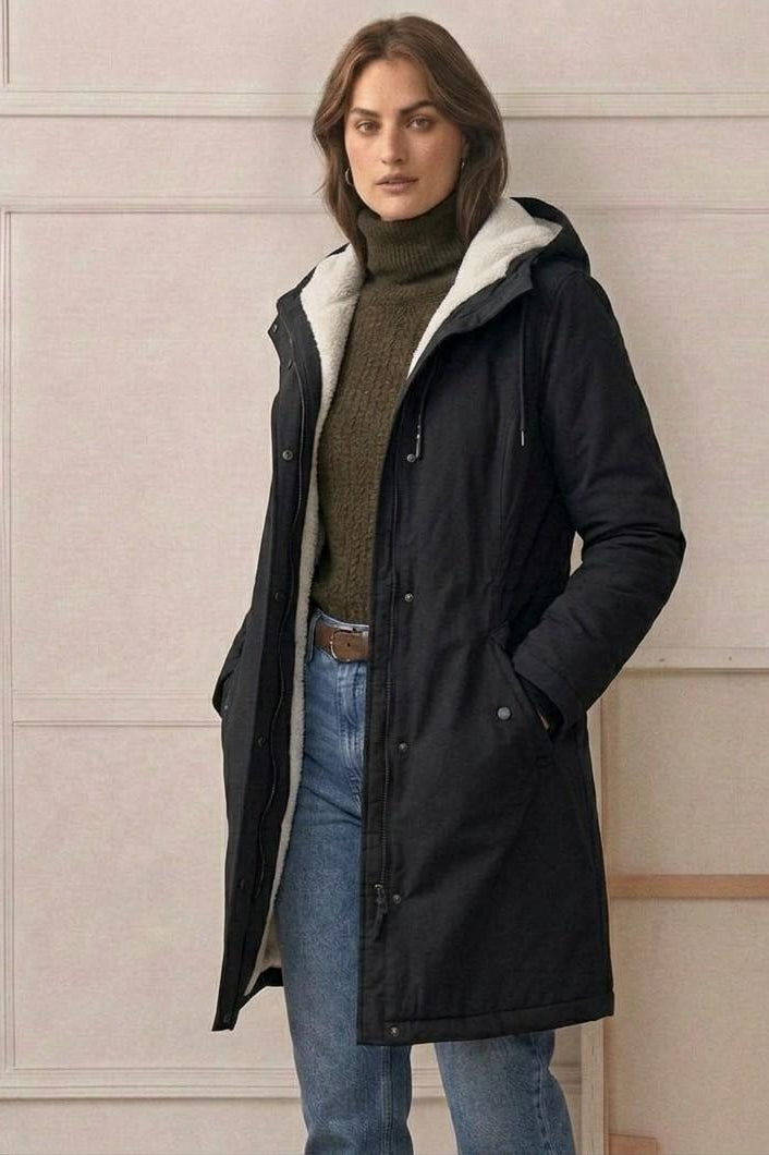 A model zipping up the Elara parka, illustrating the smooth operation of the wind-blocking closure.