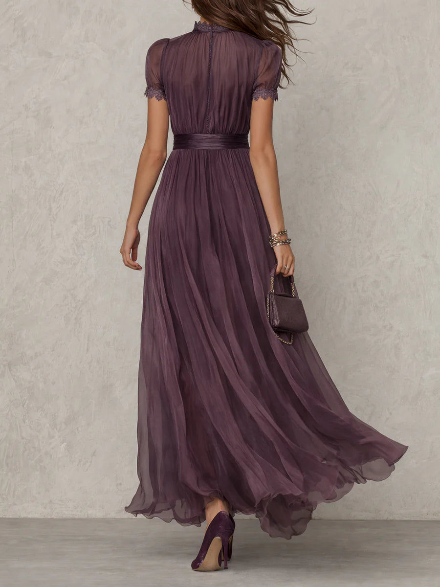 Side profile of a model wearing the Evadne purple chiffon lace maxi dress, highlighting its elegant drape and defined waist.