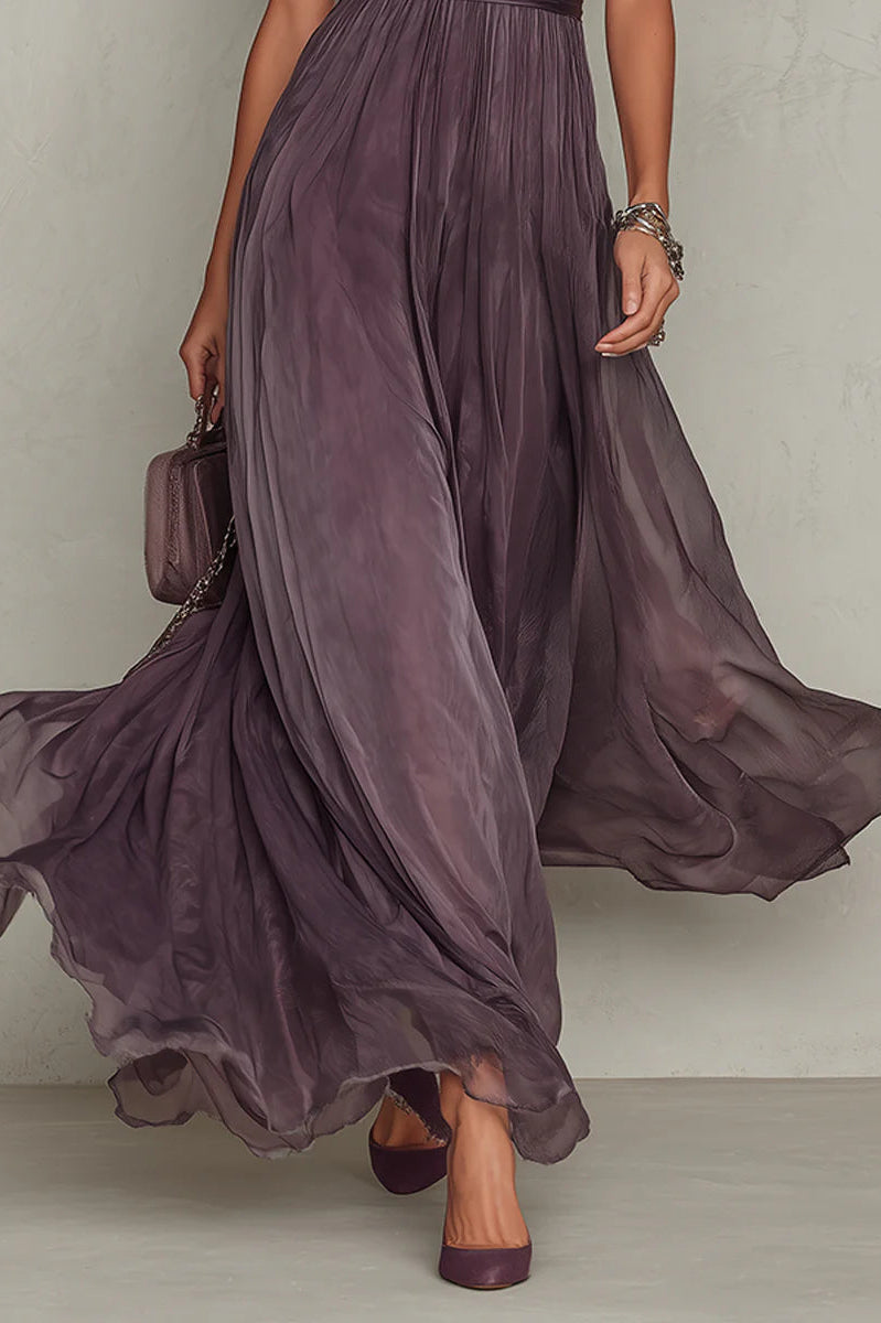 Lifestyle shot of the Evadne purple chiffon lace maxi dress in a garden setting, emphasizing its suitability for outdoor events.