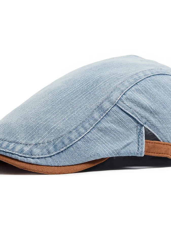 Side profile of the denim flat cap, highlighting the curved brim and tailored construction.