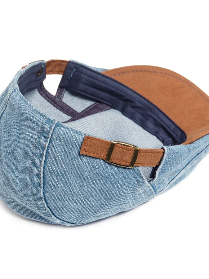 A stack of three denim flat caps in different colors (black, light blue, dark blue), showcasing the range.
