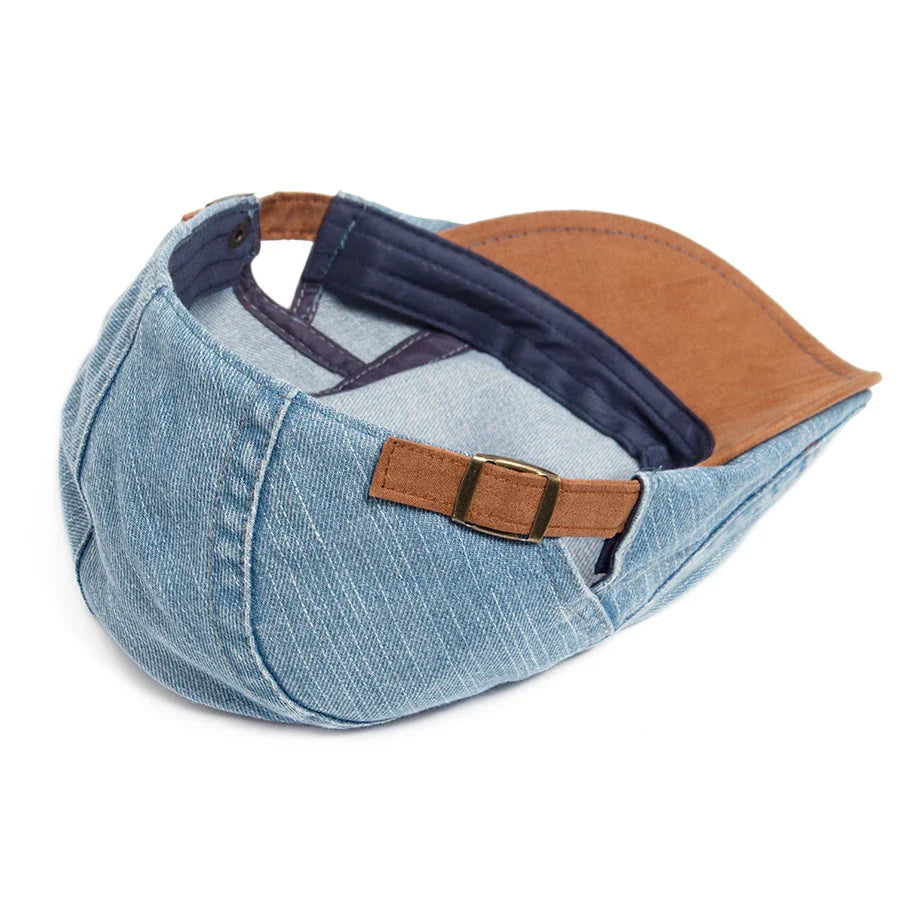 A stack of three denim flat caps in different colors (black, light blue, dark blue), showcasing the range.
