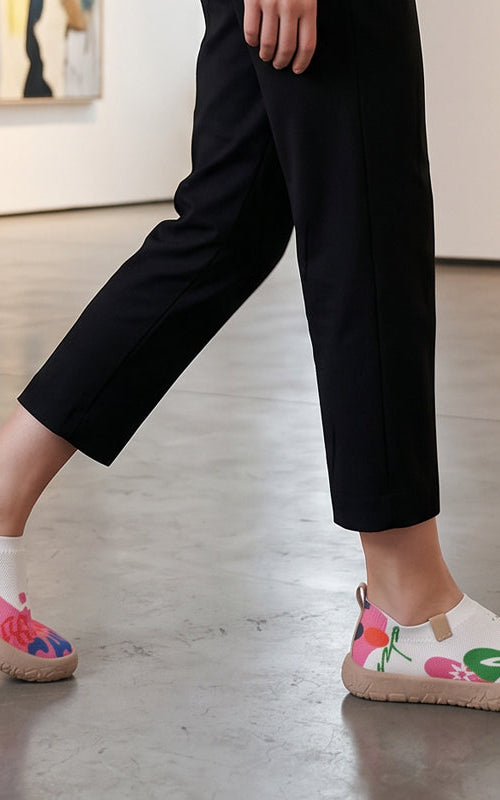 Close-up detail of the fuchsia artistic pattern on the breathable mesh upper of the slip-on shoes.